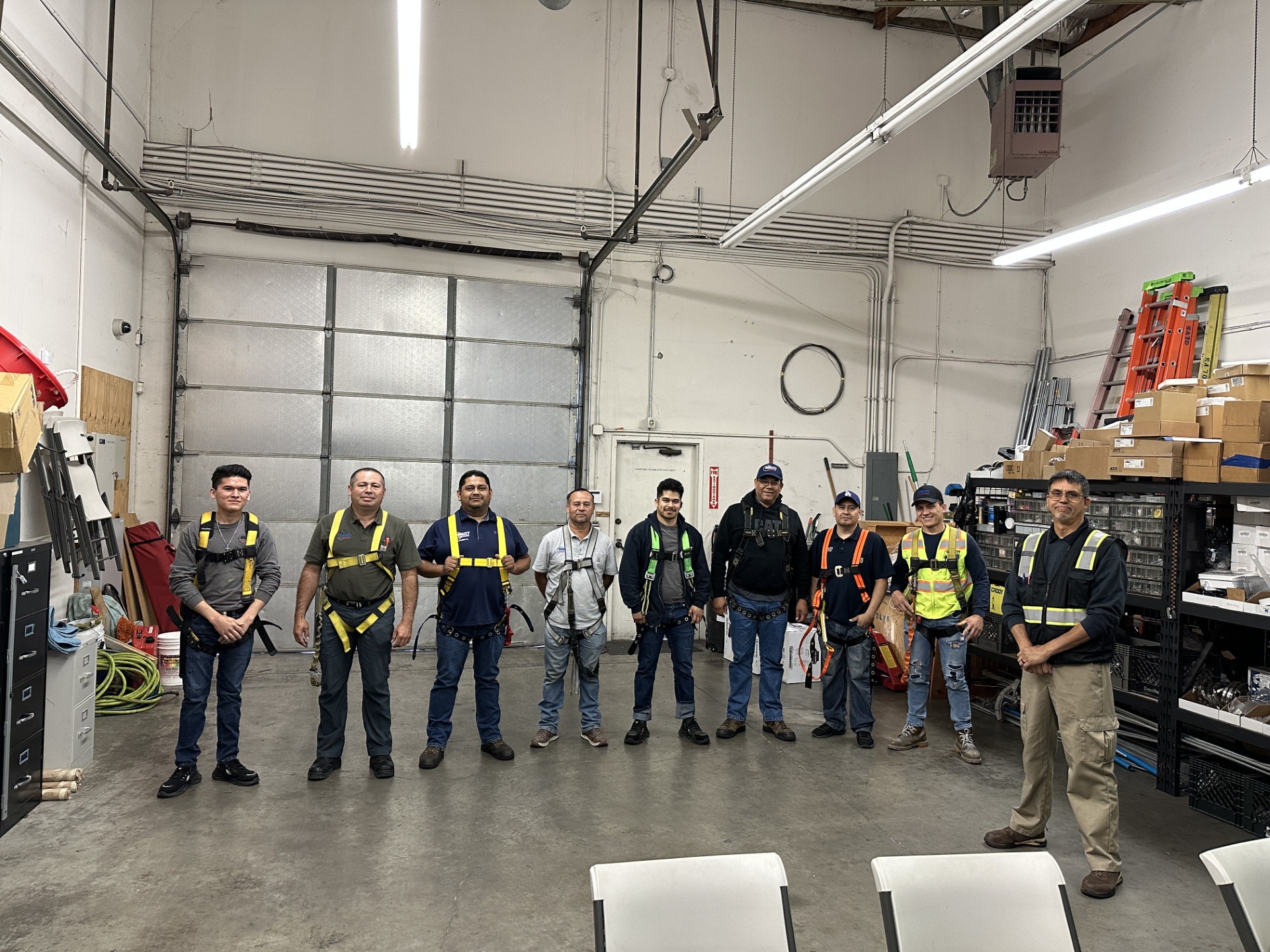 Multicultural team in workplace safety training, hands-on equipment instruction.