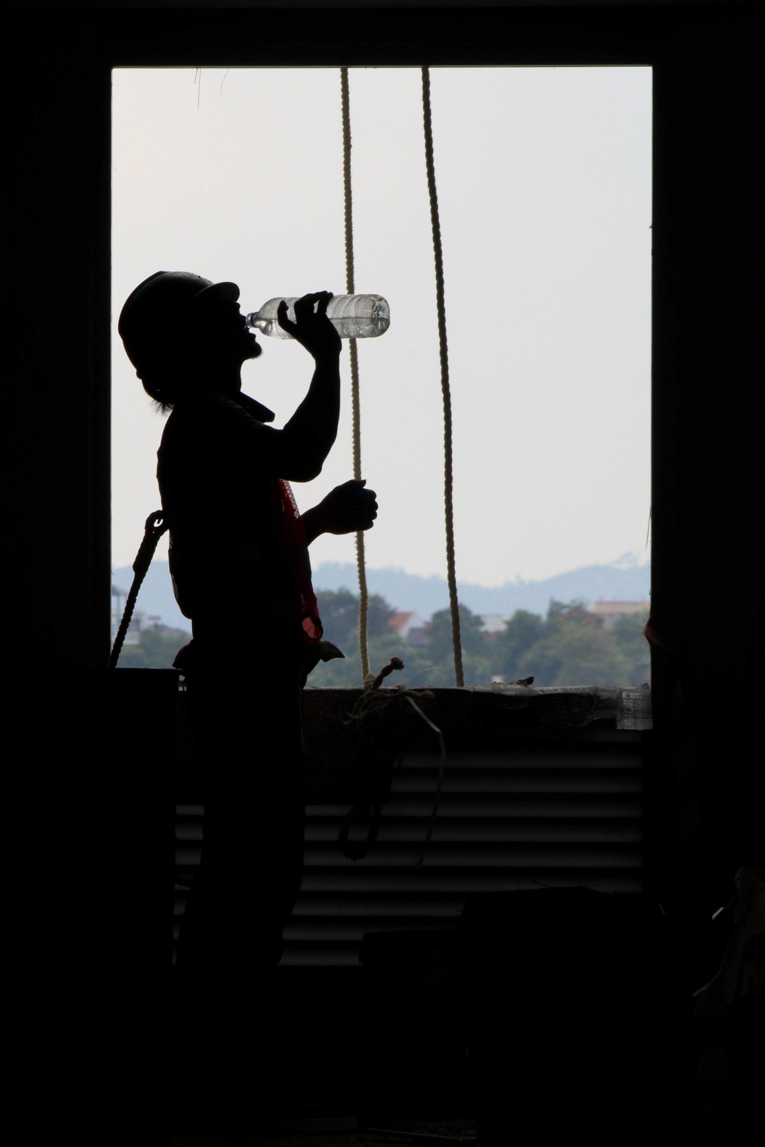 Woman applying sunscreen as part of heat illness prevention strategy during a warm day outdoors